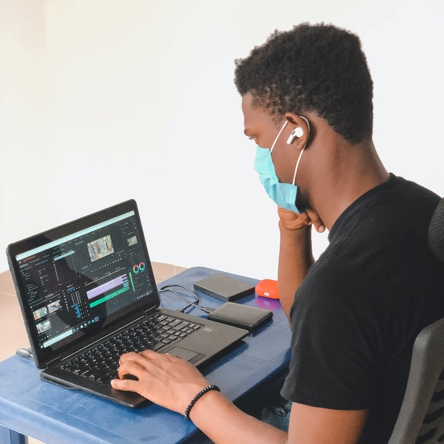 A person wearing a mask and using a computer