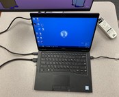 Laptop on desk with cables plugged in