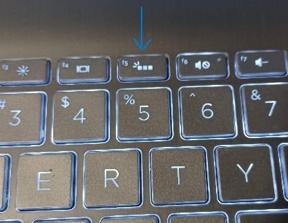 A close up of a keyboard with an arrow pointing to F5 key. The photo shows the keys are on backlight for easy read.