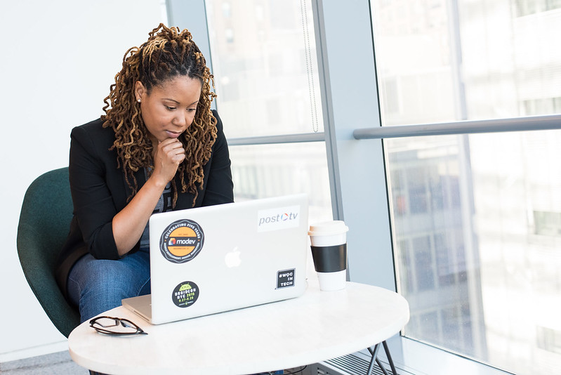 Women sitting at small desk using laptop computer